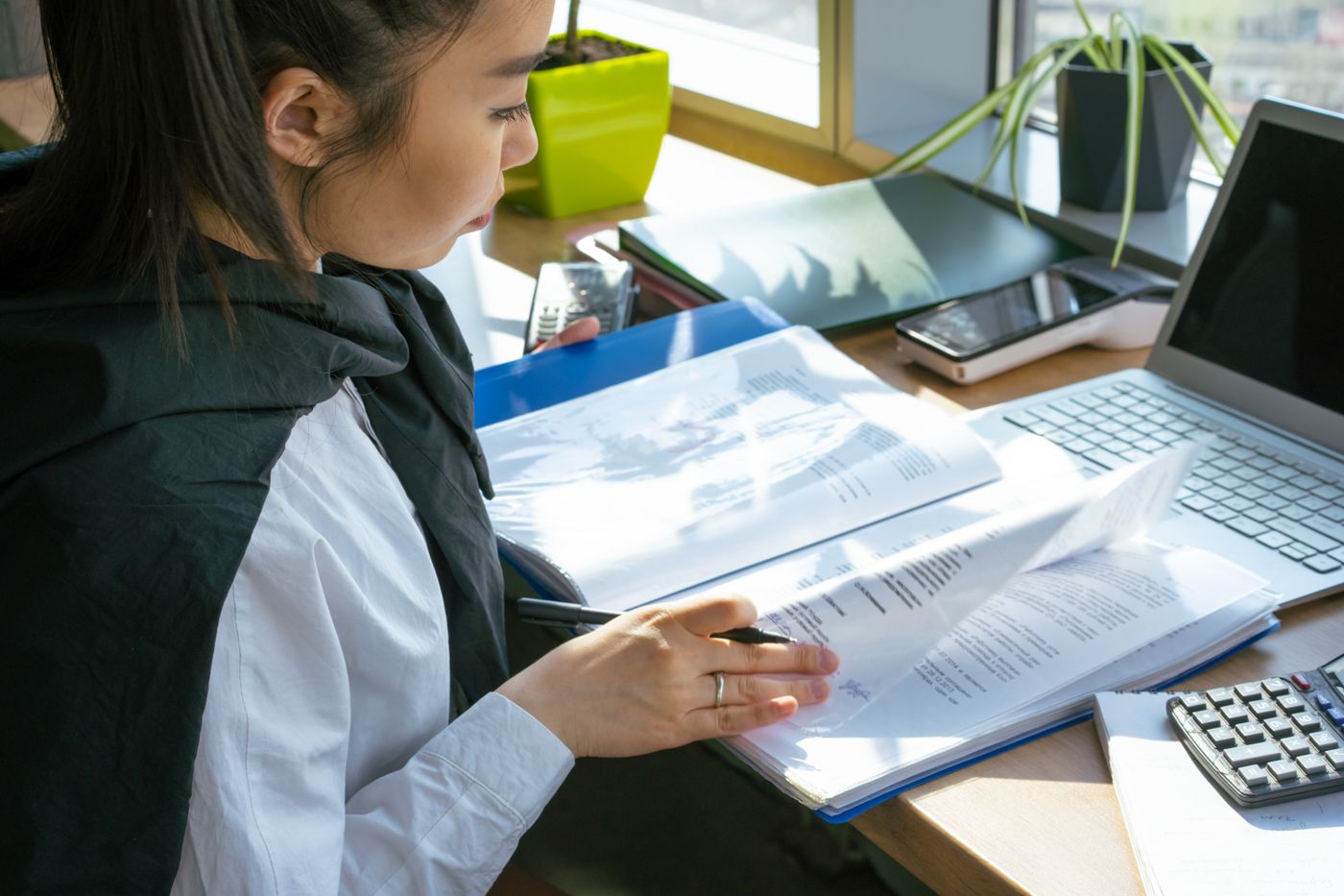 An officer reviewing documents at a desk with a laptop