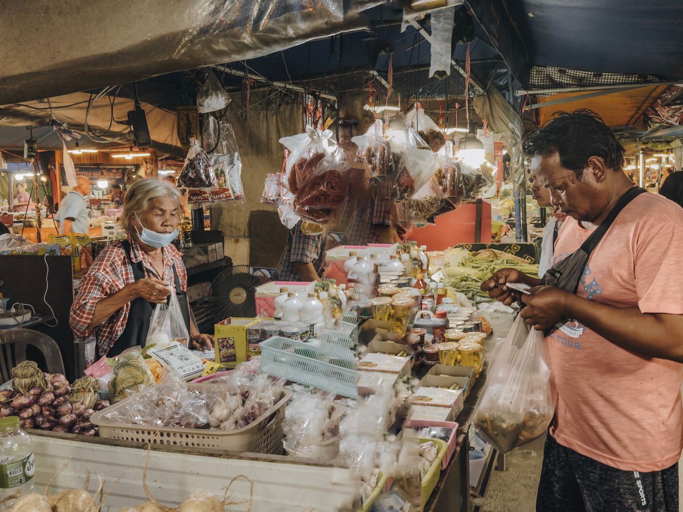 A customer checking a phone at a market stall